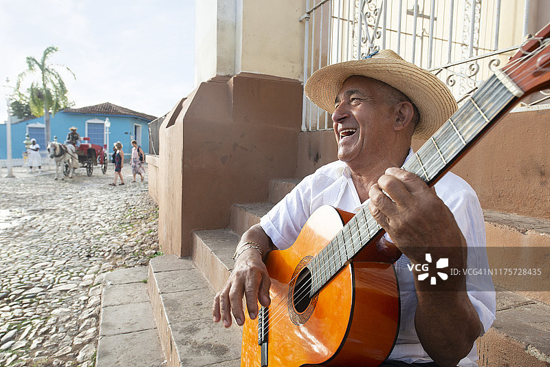 在古巴特立尼达马约尔广场唱歌弹吉他的当地男人图片素材