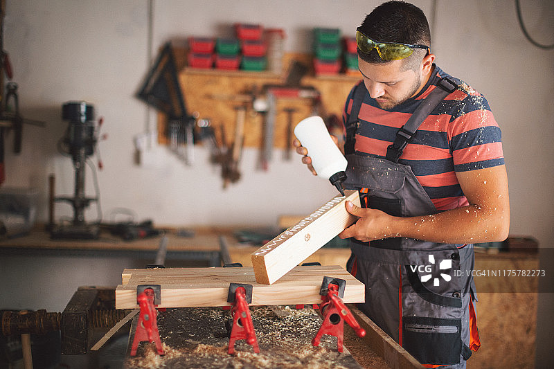 年轻木匠粘合木头图片素材