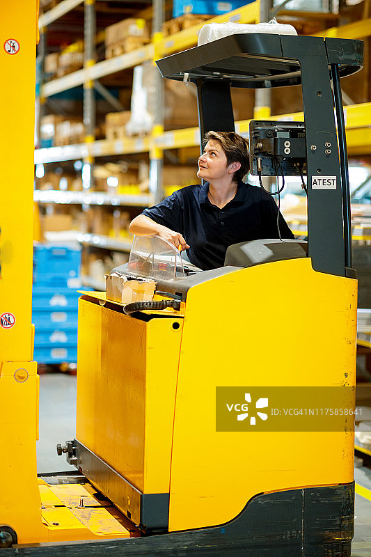 女工在仓库里驾驶叉车图片素材