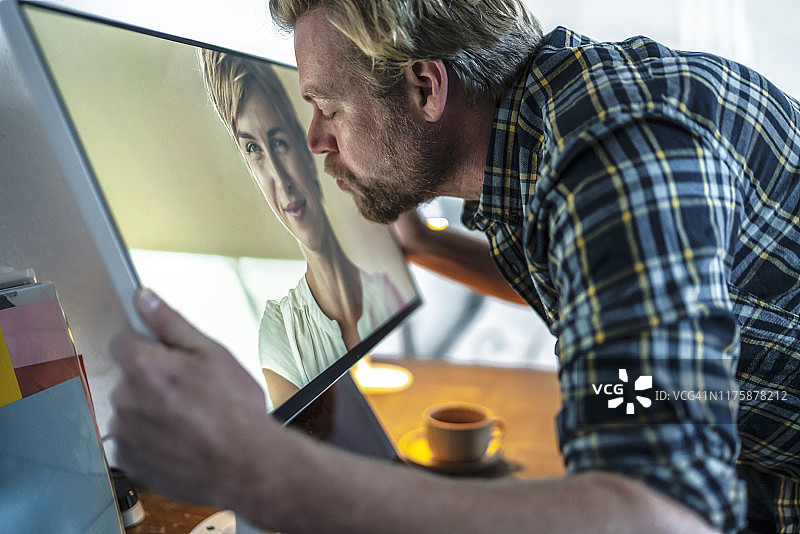 男人亲吻电脑屏幕上的女人图片素材