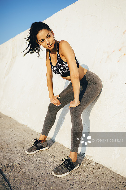 运动中靠墙休息的女人图片素材