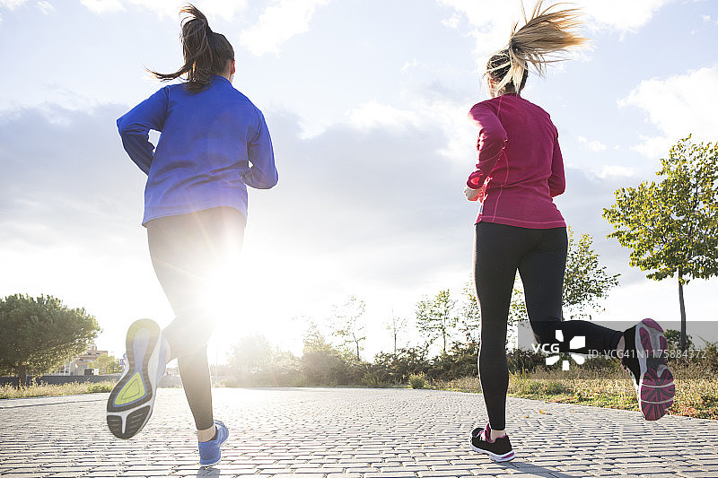 在晨曦中公园里跑步的女子背影图片素材