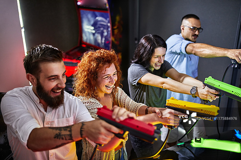 朋友们在游乐场用手枪玩射击游戏图片素材