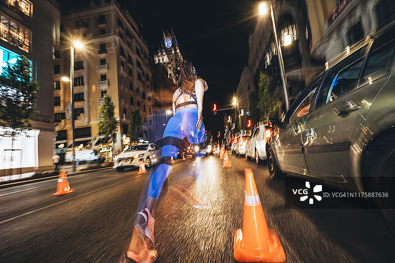 在马德里夜晚闪烁灯光中奔跑的女人图片素材