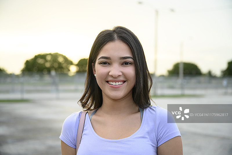 户外肖像：微笑的西班牙裔少女图片素材