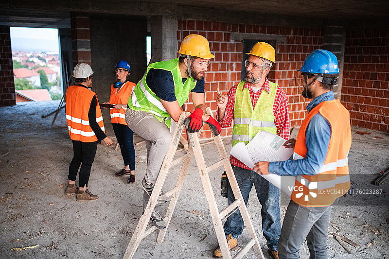 在建筑工地研究住房规划的手工工人图片素材