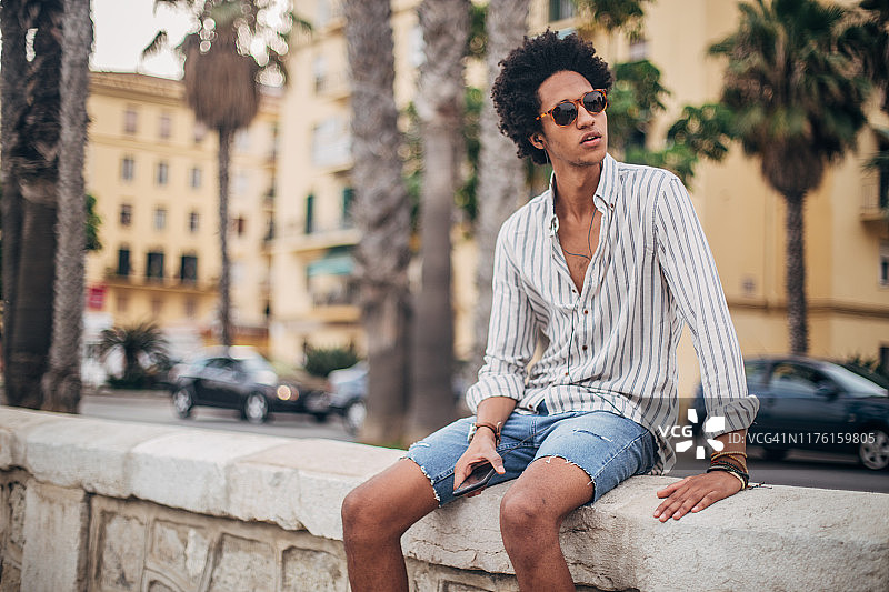 用智能手机听音乐的年轻男人图片素材