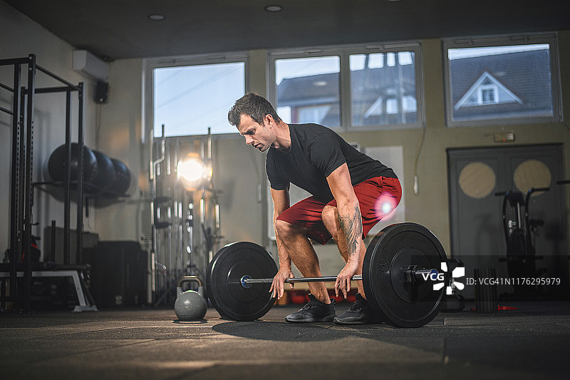 准备举杠铃的专注男运动员图片素材
