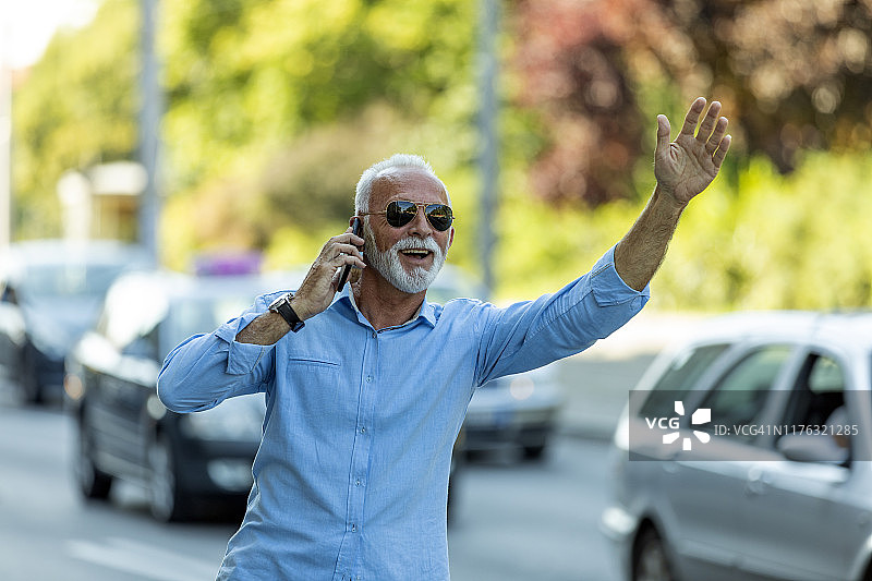 正在呼叫出租车的成熟商务人士图片素材