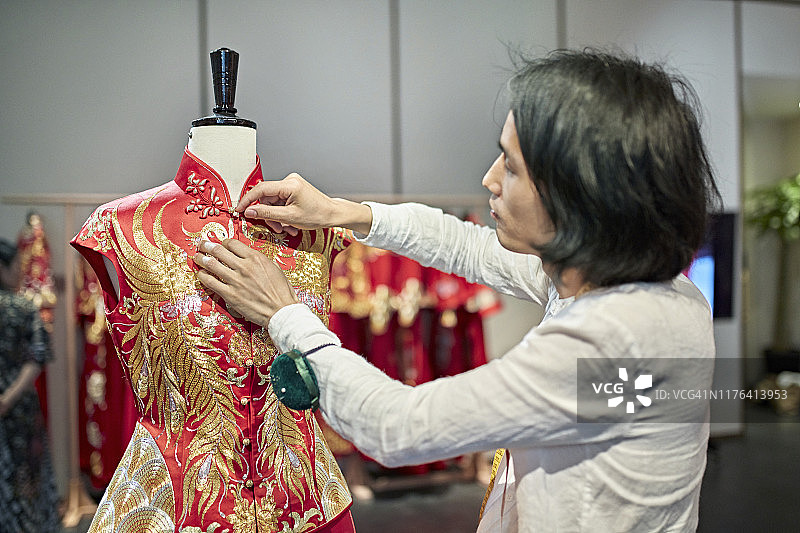 中国设计师在服装模型上整理裙褂图片素材