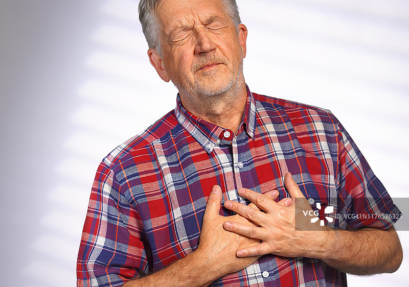 年长的男人痛苦地捂住胸口图片素材
