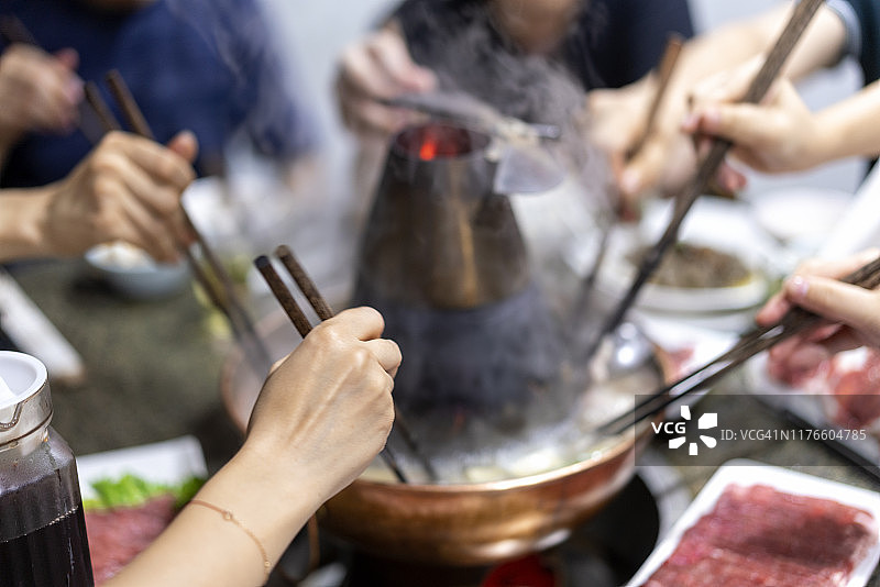 一家人在餐厅享用中国传统火锅图片素材
