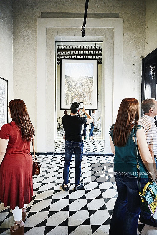 男人在博物馆用智能手机拍摄艺术品图片素材