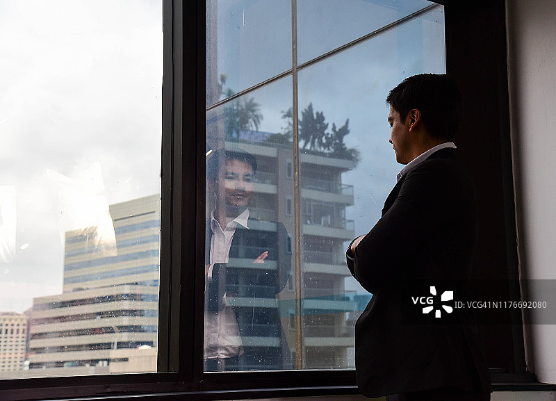 眺望窗外思考业务发展的商人图片素材