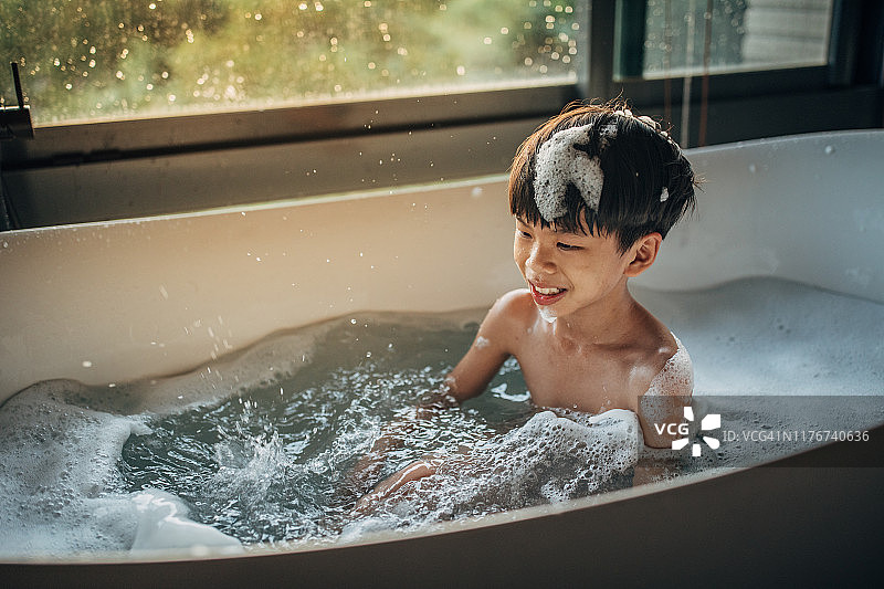 小男孩在浴缸里洗澡图片素材