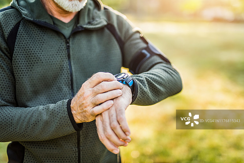 年长男人在户外使用数位手表图片素材