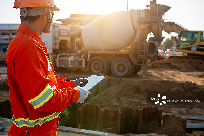工程师在户外建筑工地用平板电脑检查水泥地面浇筑情况图片素材
