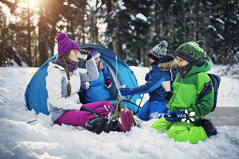 母亲和孩子们在冬季森林里露营图片素材