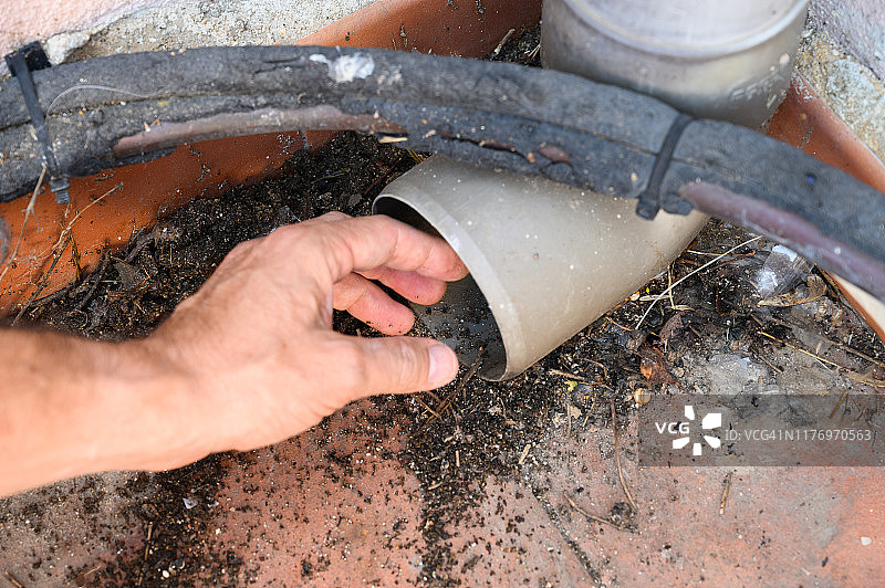 男人疏通排水沟的落水管，家庭管道维修工作图片素材