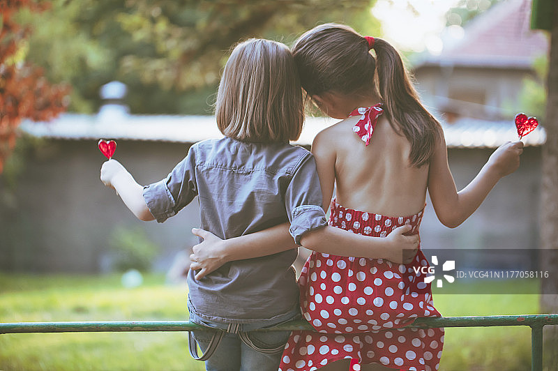 拿着棒棒糖的儿童，爱心概念图片素材