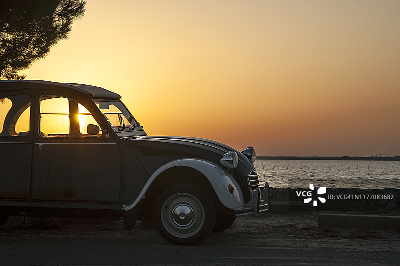 法国阿尔卡雄湾日出逆光下的复古汽车图片素材