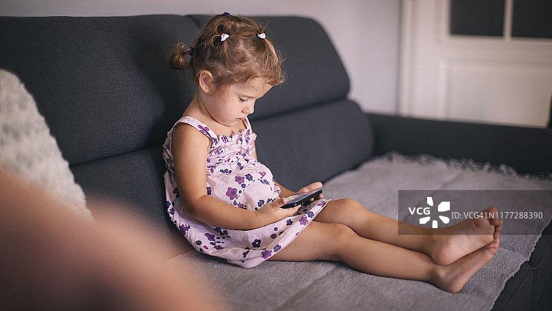 玩智能手机的可爱女婴图片素材