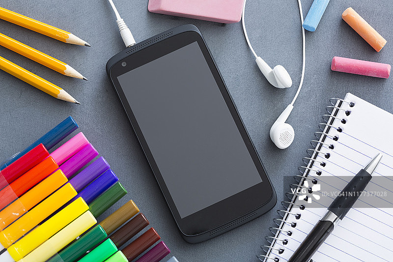 课桌上的智能手机和学习用品图片素材