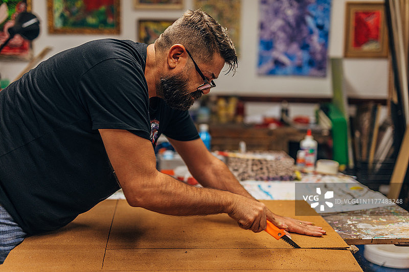 男人用刻刀切割画布图片素材