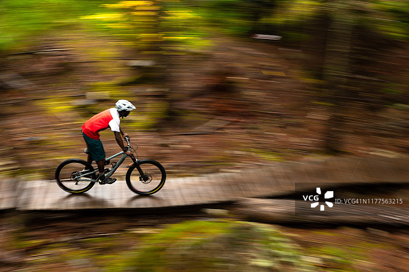 在茂密森林中进行越野山地自行车运动图片素材