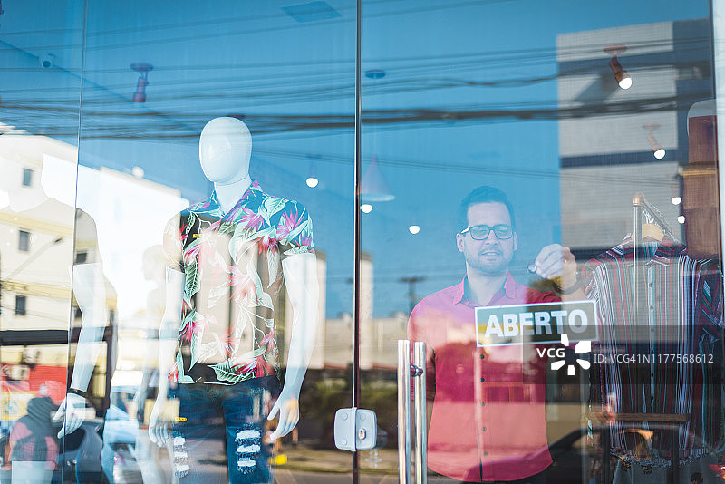 销售员在商店门上设置营业中标志图片素材