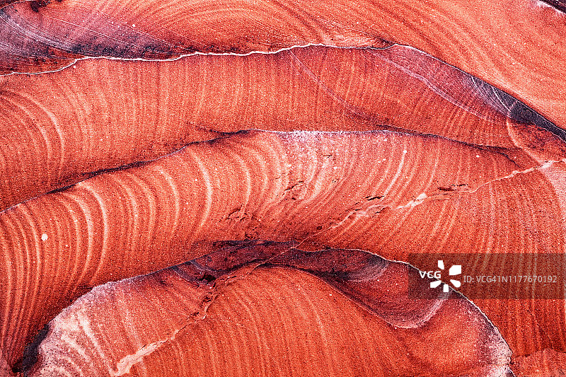 约旦佩特拉岩石表面，形成红色、白色和黄色波浪，暖光背景壁纸图片素材