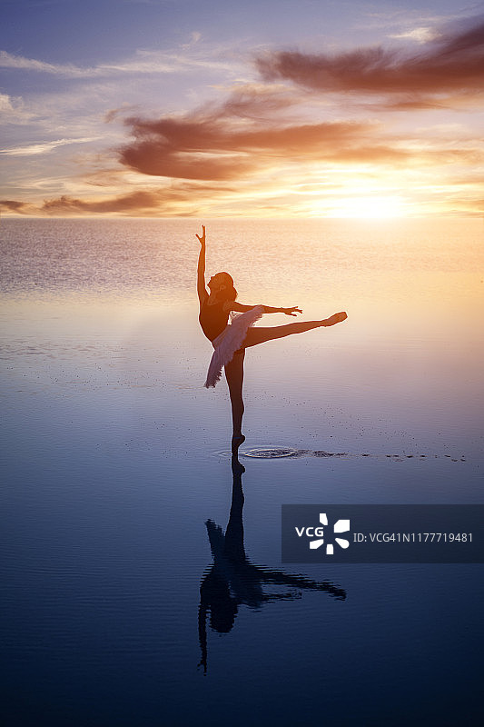 日落时在湖面上跳舞的芭蕾舞女演员图片素材