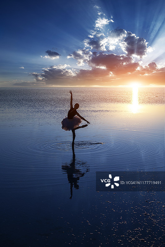 日落时在湖面上跳舞的芭蕾舞女演员图片素材