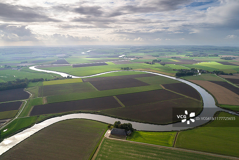 典型的荷兰农业景观中的蜿蜒河流图片素材