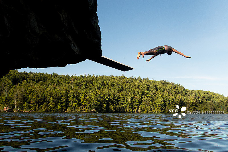年轻人头朝下跳入湖中图片素材