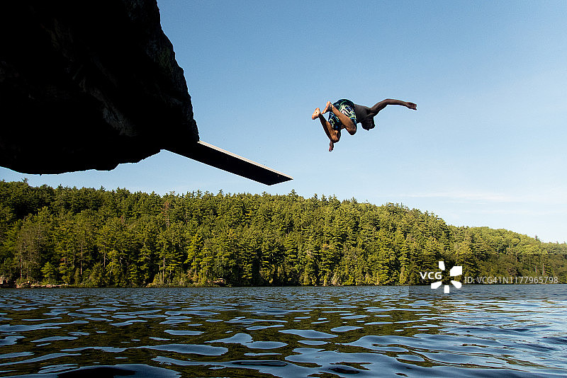 年轻人头朝下跳入湖中图片素材