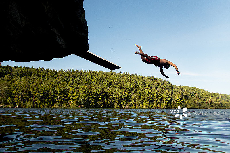 年轻人头朝下跳入湖中图片素材