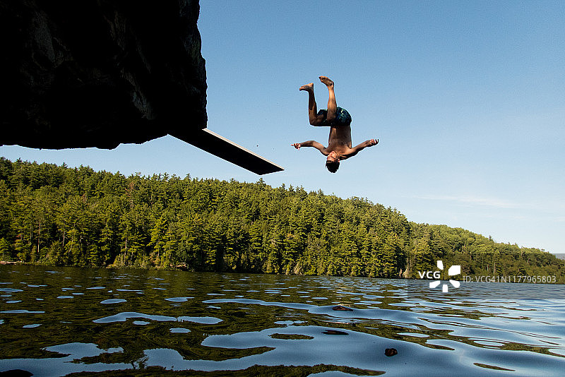 年轻男人向后空翻跳入湖中图片素材