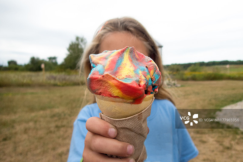 拿着彩色冰淇淋甜筒的年轻女孩图片素材