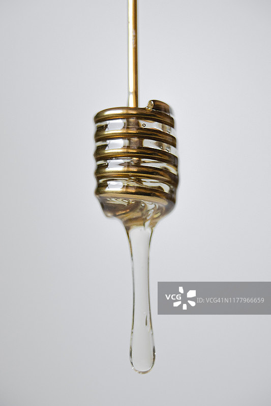 蜂蜜勺滴着蜂蜜特写图片素材