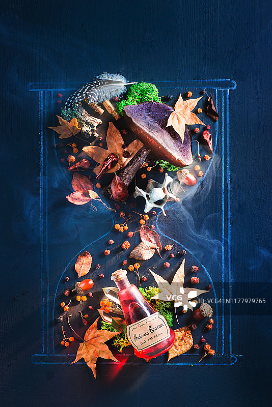 沙漏的粉笔画与真正的落叶、苔藓、橡子和秋季药水。以秋季为主题的黑暗魔法平面图图片素材