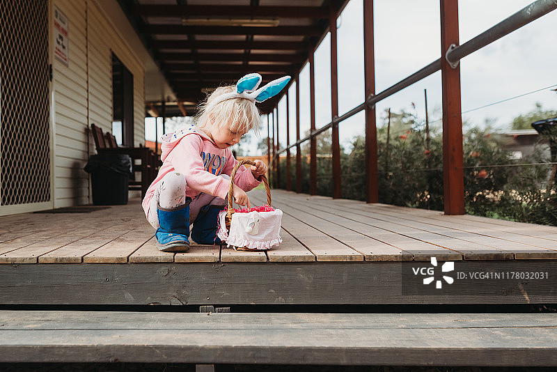戴着兔子耳朵捡复活节彩蛋的小孩图片素材