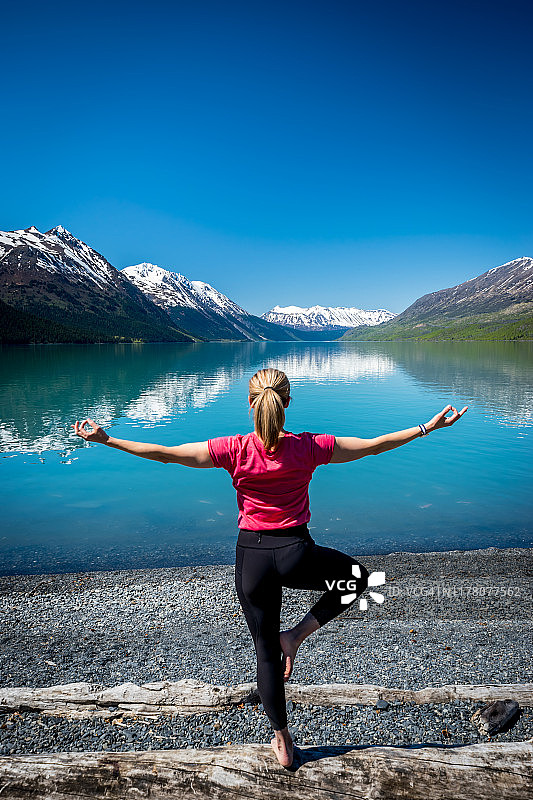 在湖边和山脉旁做瑜伽的女人图片素材