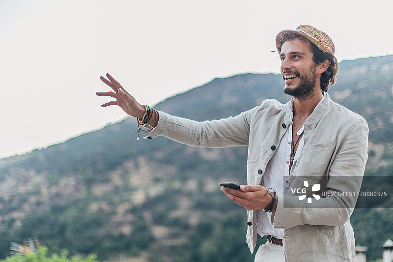 使用手机并挥手的男人图片素材