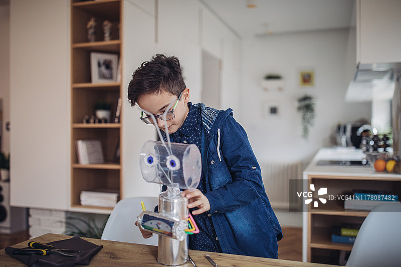 聪明的男孩工程师在家建造机器人图片素材