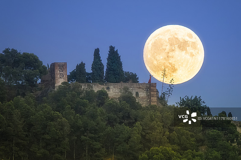 身穿长裙试图触摸满月的女人图片素材