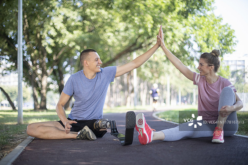 在公园里与女教练一起锻炼的残疾青年图片素材