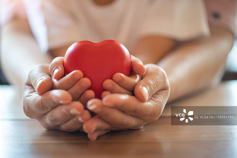 大人和孩子手捧红心，健康护理、捐赠及家庭保险理念，世界心脏日、世界健康日图片素材