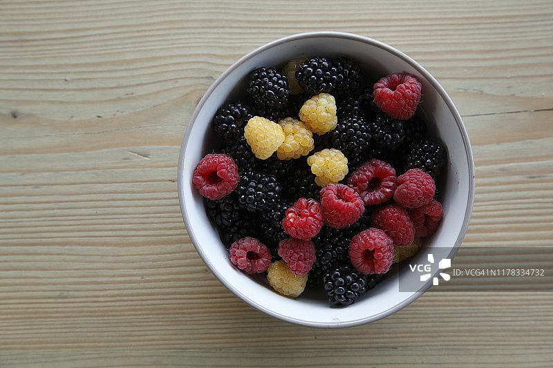 碗里新鲜采摘的彩色夏季浆果图片素材