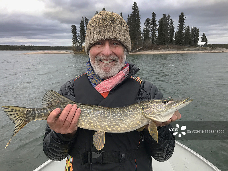 凯文·谢弗在加拿大西北地区的布拉奇福德湖抱着北方梭鱼图片素材